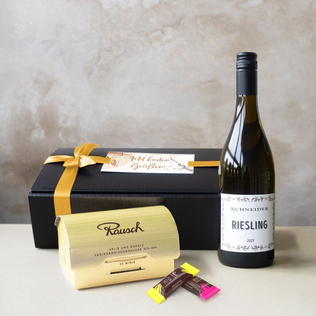 Geschenkbox mit Weißwein, Schokolade, individueller Karte und Schleife.