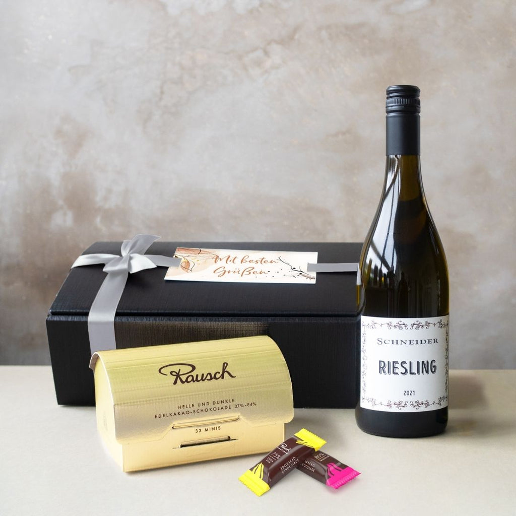 Geschenkbox mit Weißwein, Schokolade, individueller Karte und Schleife.