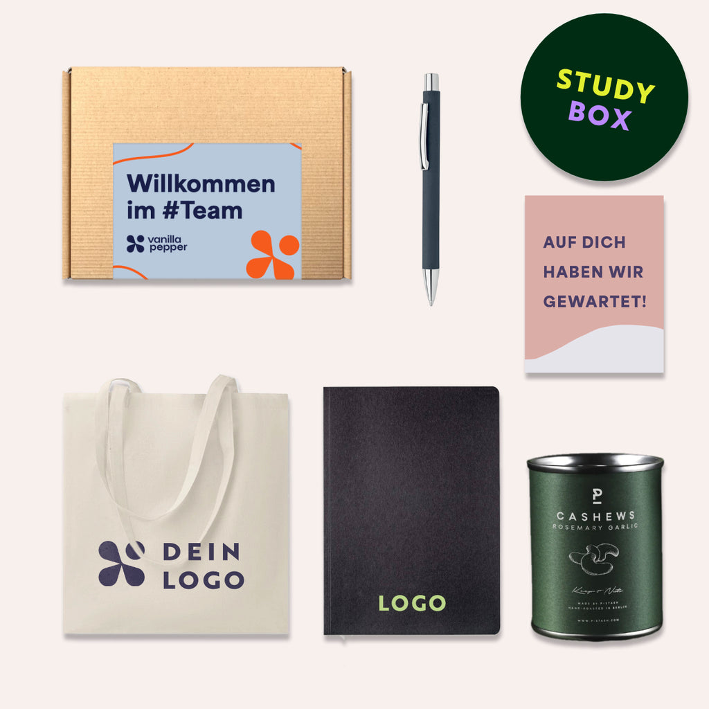 Die Geschenkbox enthält ein Notizbuch aus Recyclingpapier, Stoffbeutel, Kugelschreiber und Nüssen.