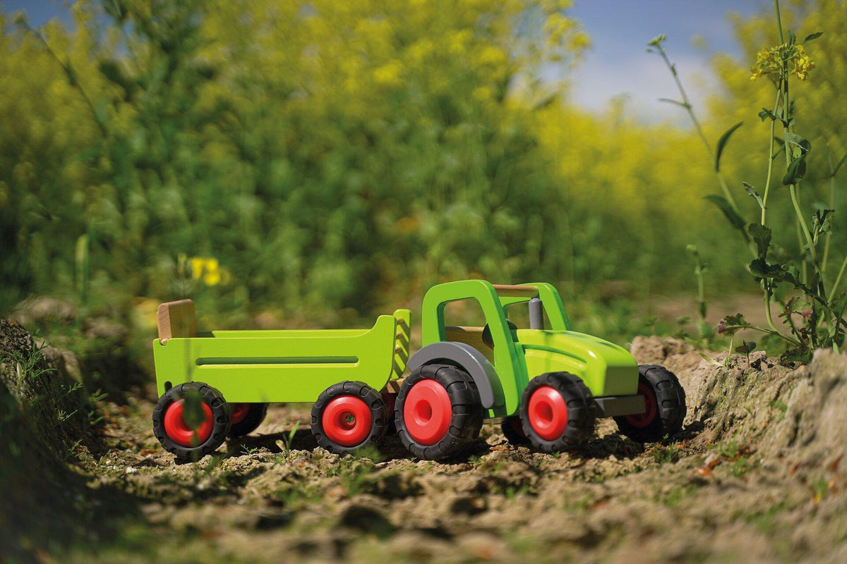 Holztraktor in Grün mit Heuwagen und roten Rädern – weitere Ansicht